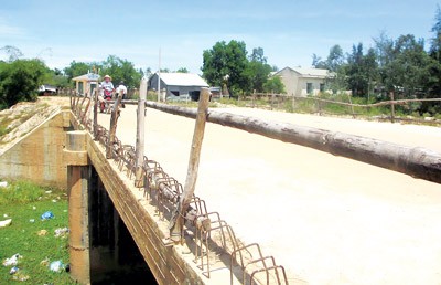 A temporary bamboo railing lines the edge of the bridge (Photo: SGGP)